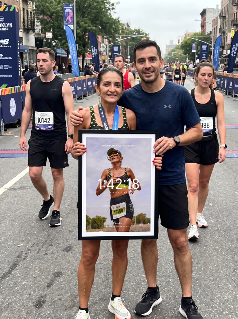 Half marathon finisher with partner holding her print